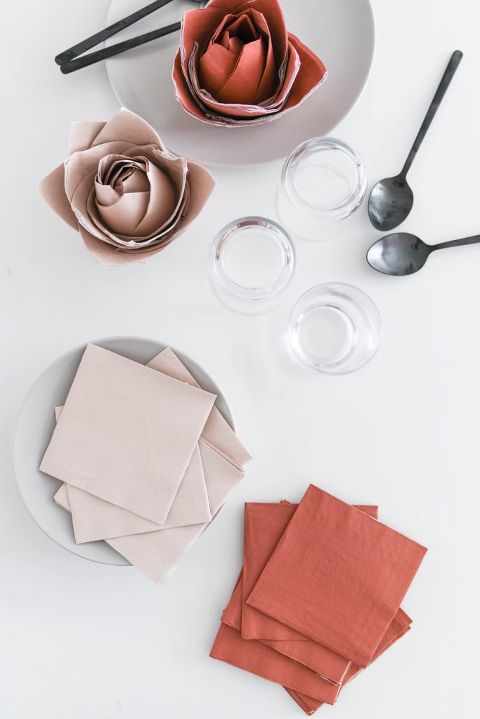 Tischdeko-Idee für den Valentinstag: Elegante Servietten-Rosen im Glas falten
